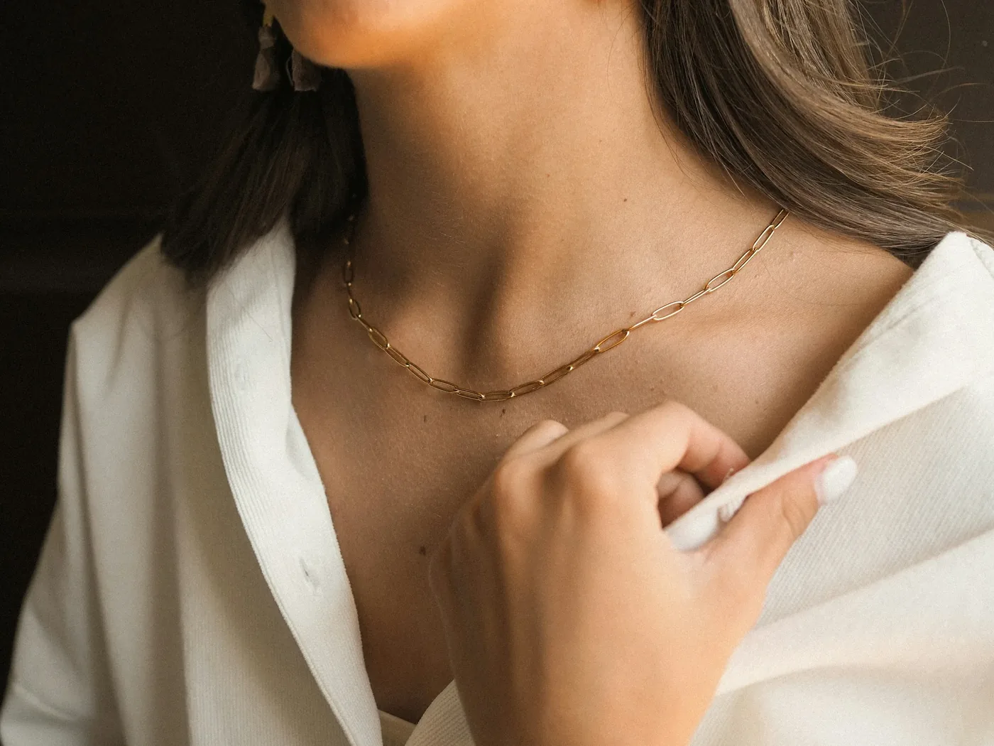 Una collana in oro su una camicia bianca